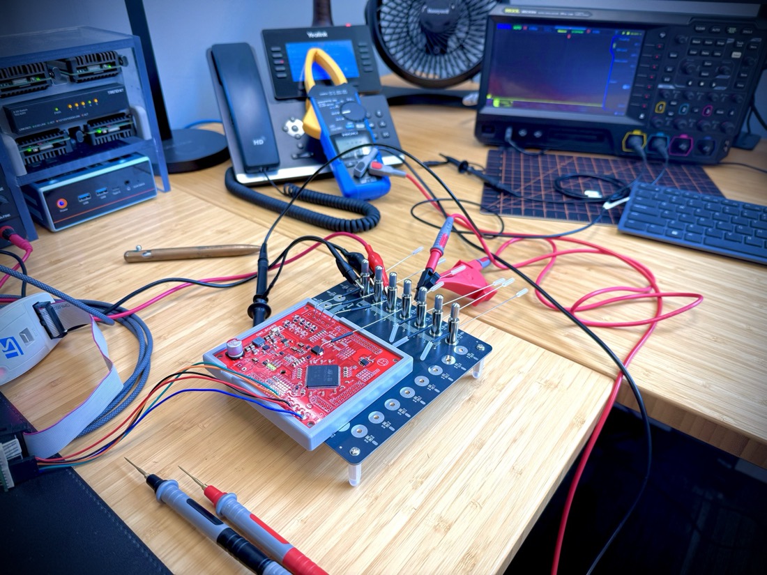 ONE_BOARD on the bench in a pogo-pin fixture, probes attached